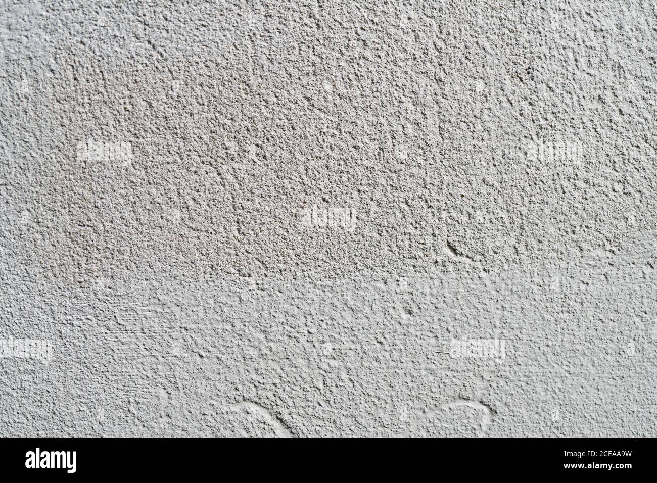 Weiße oder graue Betonwand ist eine dekorative oder strukturierte Oberfläche. Kann als Hintergrund oder für Designzwecke verwendet werden Stockfoto