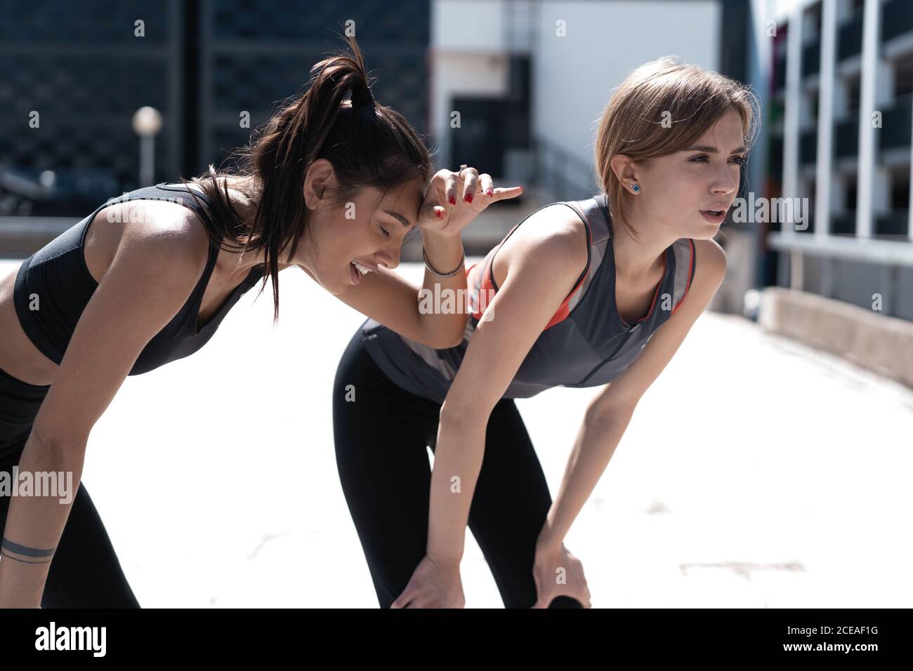 Zwei Freundinnen entspannen sich nach dem Laufen in der Stadt. Stockfoto