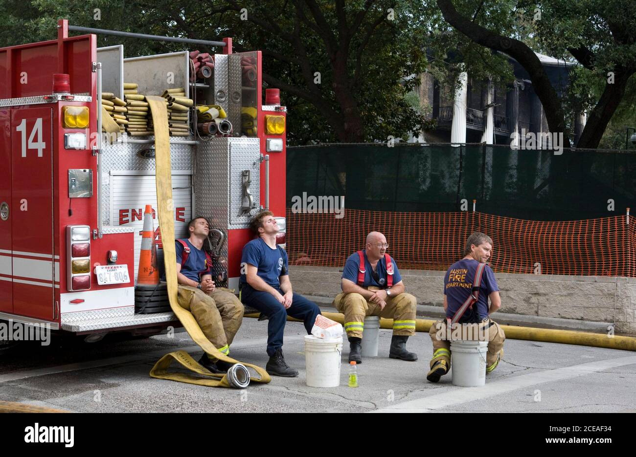 Austin, TX 8. Juni 2008: Müde Feuerwehrleute machen eine Pause, nachdem sie auf ein frühmorgendliches Feuer mit vier Alarmen reagiert haben, das das Landgut des Gouverneurs von Texas in der Innenstadt von Austin ausrottete. Mehr als 100 Feuerwehrleute kämpften um die Rettung der 152 Jahre alten Struktur. Das Gebäude wurde gerade renoviert und alle historischen und antiken Möbel waren im Lager. Beamte vermuten, dass das Feuer von einem Brandstifter ausgelöst wurde. ©Bob Daemmrich Stockfoto