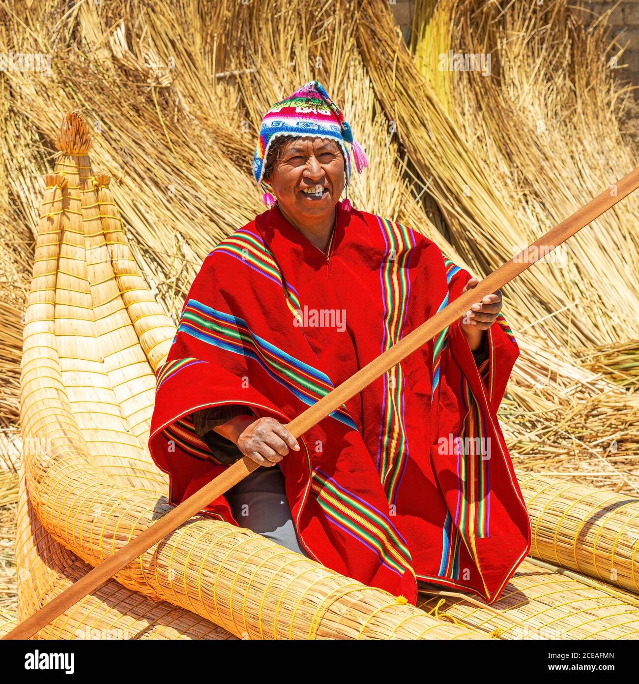 Bolivianischer Aymara indigener Mann mit traditioneller Kleidung in seinem traditionellen Totora-Schilfboot, Titicaca-See, Bolivien. Stockfoto