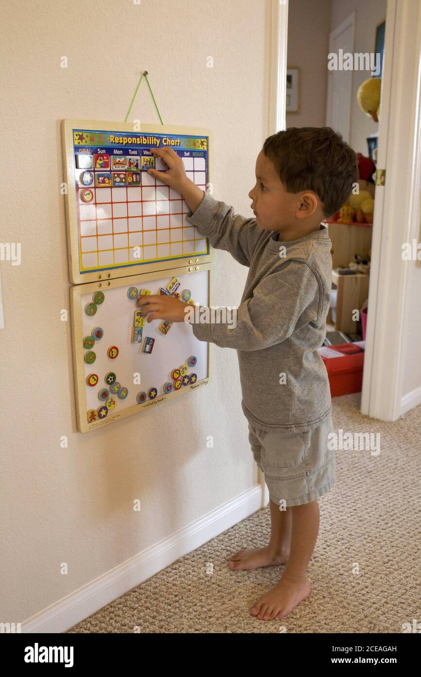 Hispanischer 4-jähriger Junge platziert Fliesen auf seinem Hauptverantwortungstabelle. HERR ©Bob Daemmrich / Stockfoto