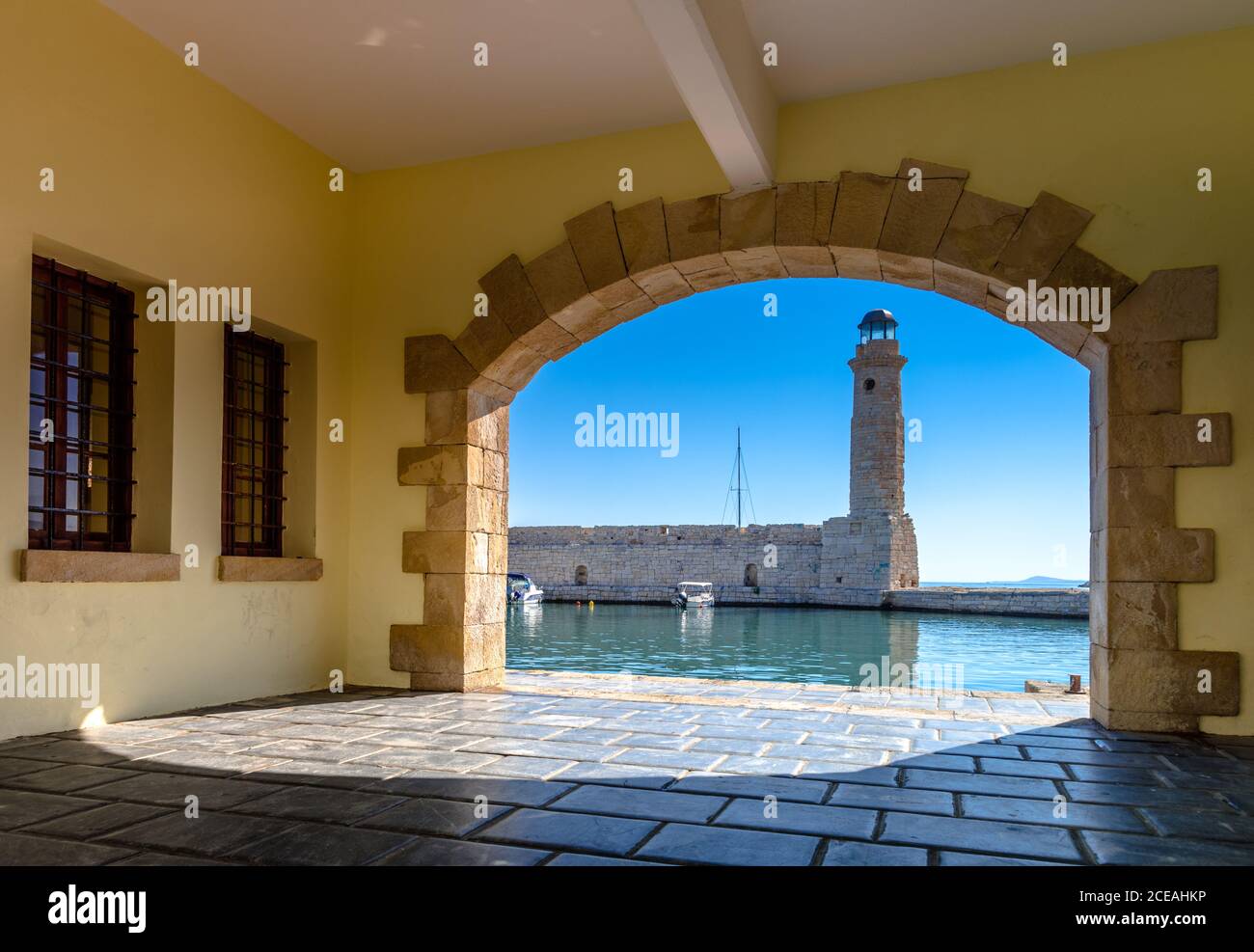 Der ägyptische Leuchtturm am alten Hafen von Rethimno durch einen Rahmen einer gewölbten Tür, Kreta, Griechenland. Stockfoto
