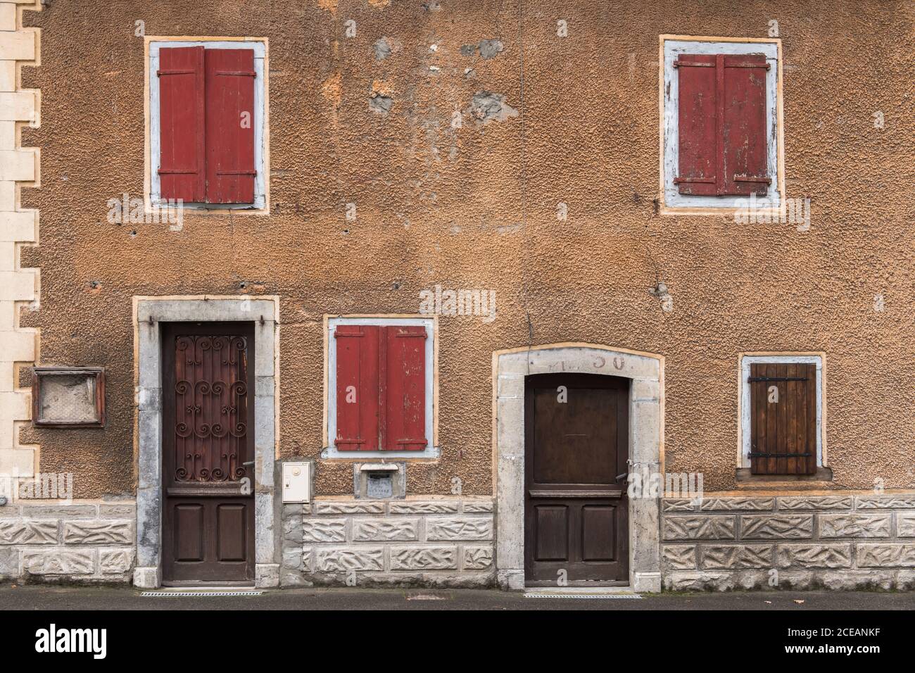 Altes Haus mit roten Fenstern und braune Türen in Pyrenäen Stockfoto