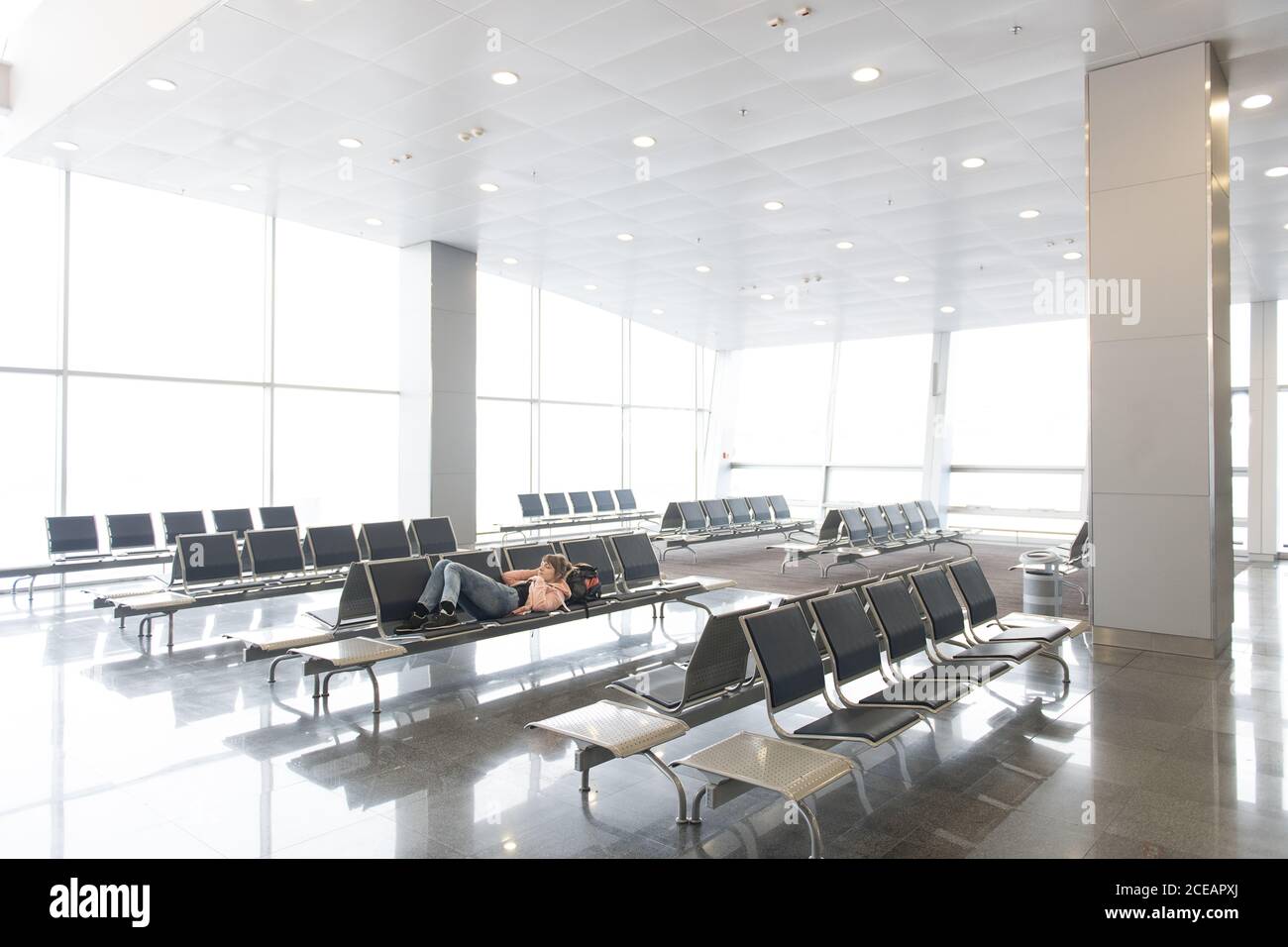 Touristenfrau liegt und ruht auf der Bank im Terminal in Thailand. Stockfoto