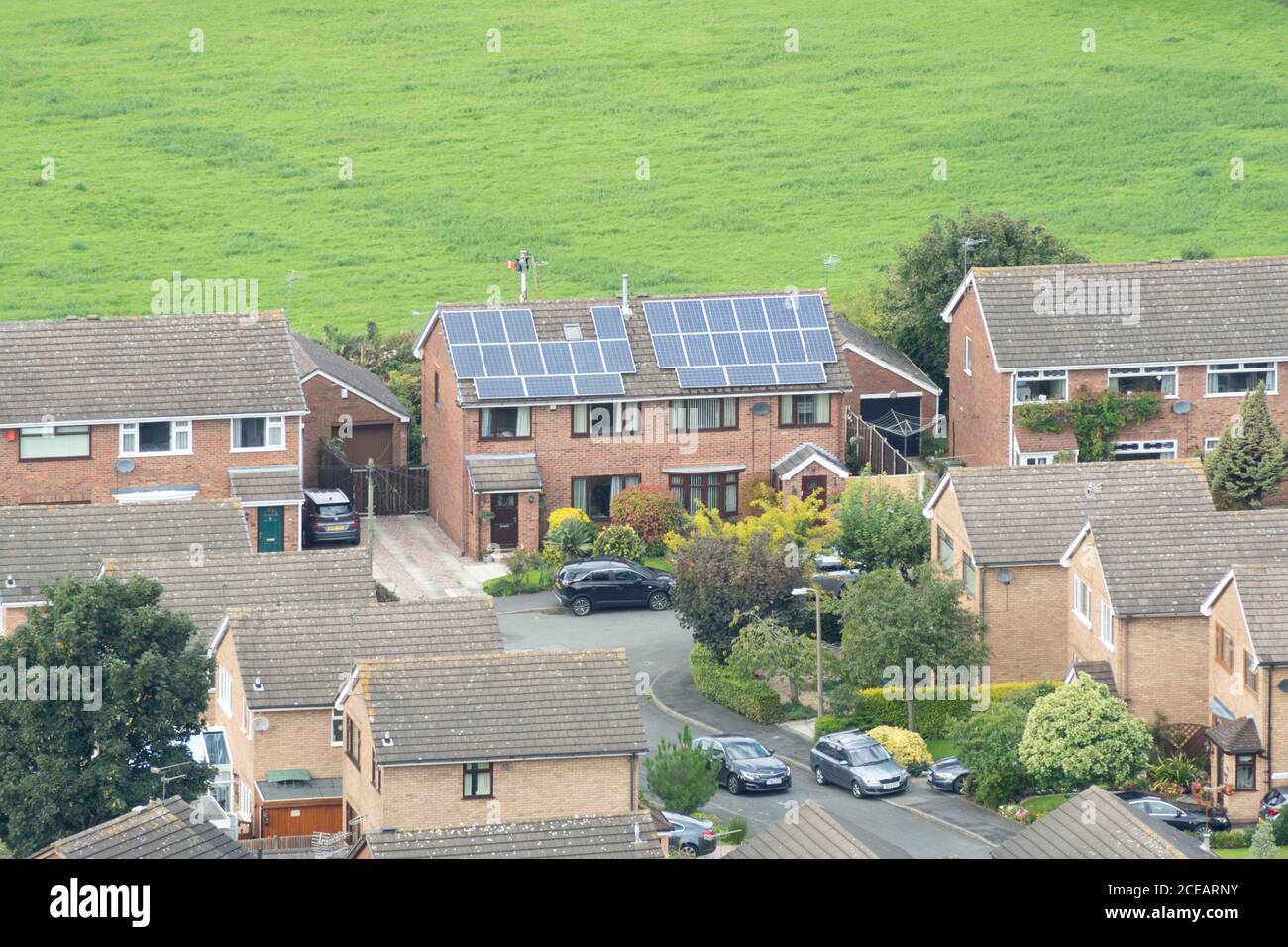 Haus mit Sonnenkollektoren auf dem Dach, erneuerbare Energie, grün, Immobilien, Haus, Wohn, Großbritannien Stockfoto