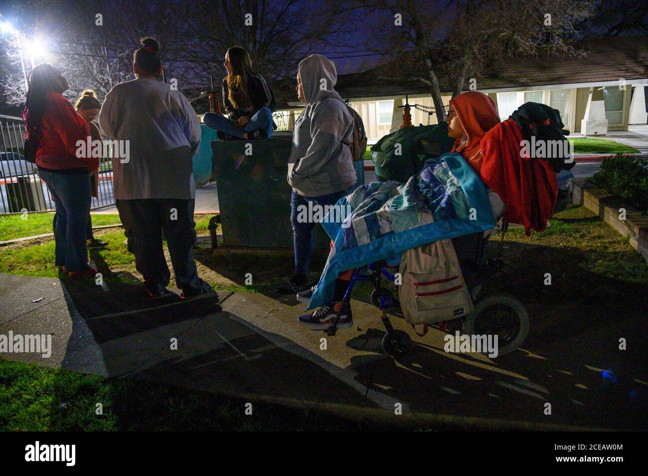 Sacramento, Kalifornien, USA. Februar 2020. Felicia Brent-Velasquez, rechts, ist in Decken gebündelt, als ihre beiden Schwestern Paulina, Mitte, und Angelique, sitzen auf einem Container, ihre Mutter Felicia Clark, zurück zur Kamera, vor dem Kinderheim von Sacramento für die wöchentliche Protest ihrer Mutter am Freitag, 14. Februar 2020. Angelique ist ein Bewohner des Hauses und war aus dem AWOL gegangen und wurde von zwei Mitarbeitern auf der linken Seite beschattet. Quelle: Renée C. Byer/ZUMA Wire/Alamy Live News Stockfoto