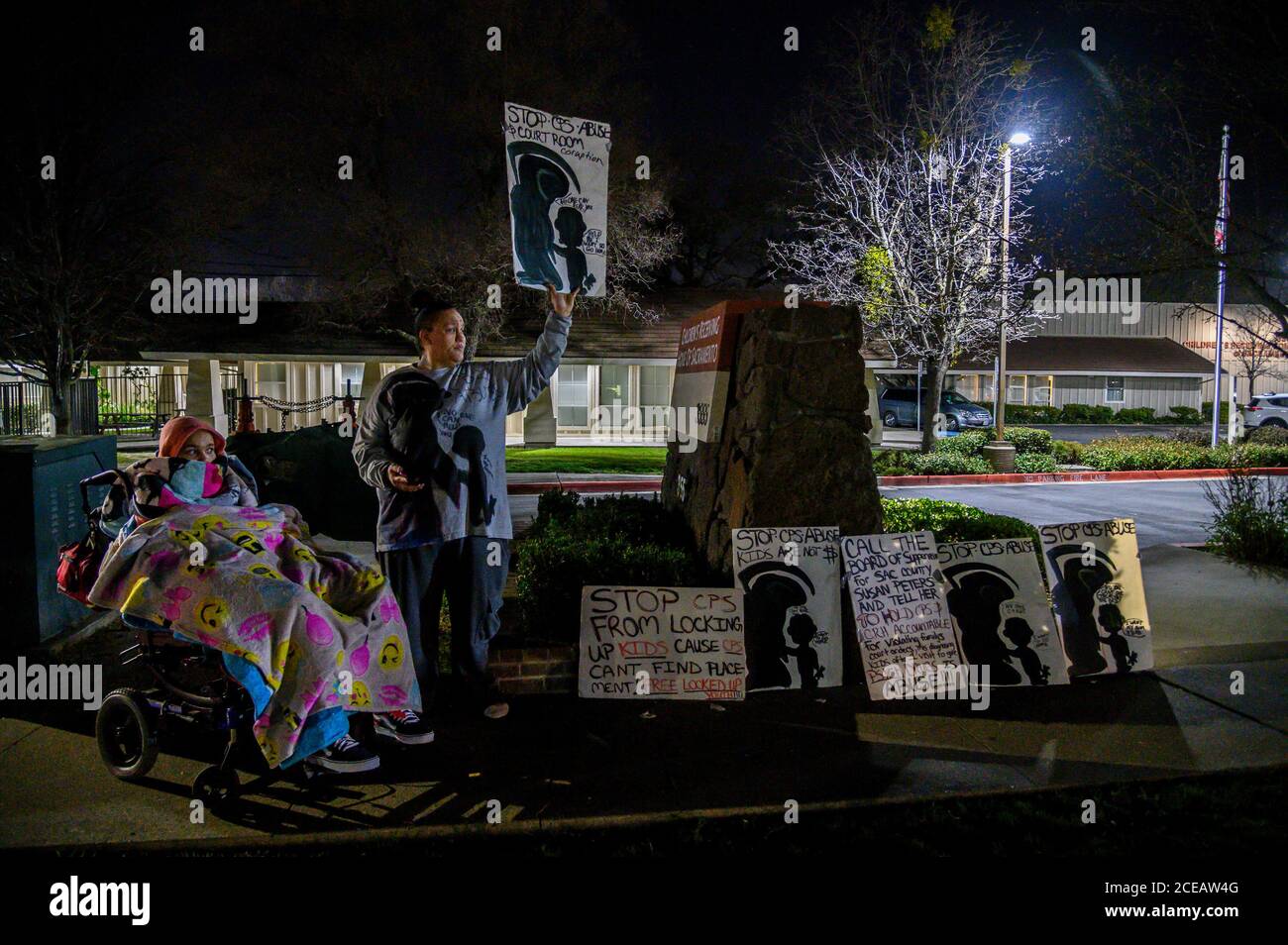 Sacramento, Kalifornien, USA. Februar 2020. Felicia Clark protestiert vor dem Kinderheim von Sacramento mit der Tochter Felicia Brent-Velasquez, 18, in Decken in ihrem Rollstuhl gehüllt, am Freitag, den 14. Februar 2020 in Sacramento. "Es ist schwer, die Dinge zu sehen, die ich dort draußen sehe, aber deshalb gehe ich immer wieder zurück. Ich möchte dort für einen Freitag herausstechen und nichts sehen. Ich möchte keine Kinder sehen. Ich möchte, dass die Menschen das tun, was sie tun sollen. Kinder gehen und gehen und Aktivitäten machen, Eltern kommen glücklich, eine Art von Prozess zu sein", sagte Clark. (Kredit I Stockfoto