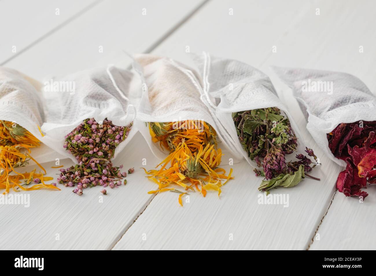 Filter Teebeutel gefüllt mit trockenen Heilkräutern - Majoran, Heidekraut, Ringelblumen und Rosenblüten. Alternative Medizin. Stockfoto