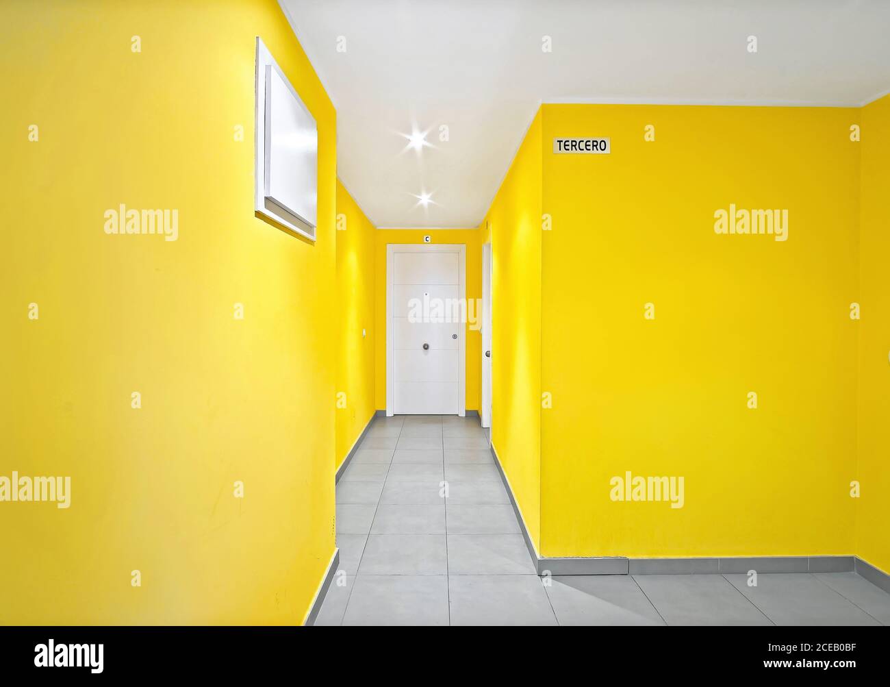 Gelbe Wände mit weißen Türen des schmalen Flurs in modernem Stil Gebäude Stockfoto