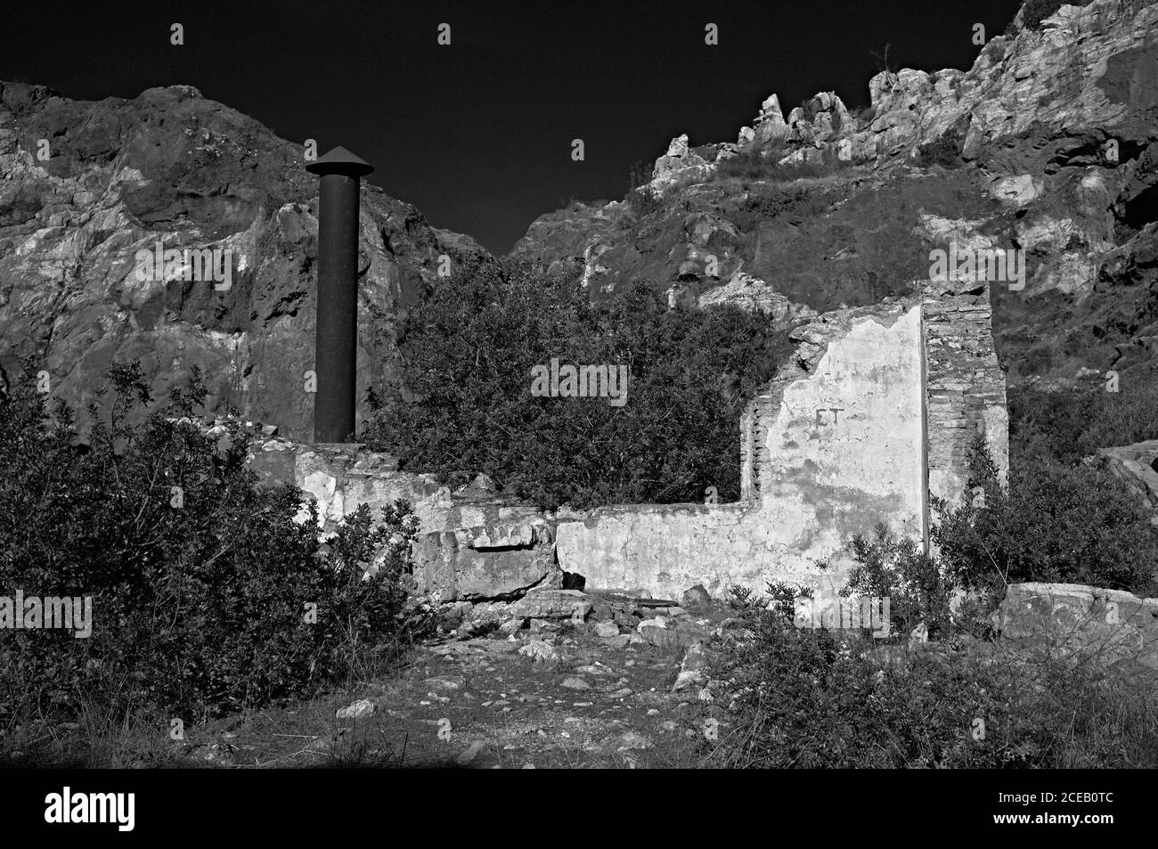 Verlassene halb zerstörte Gebäude aus Stein stehen in riesigen Feld in schwarz-weißen Farben Stockfoto