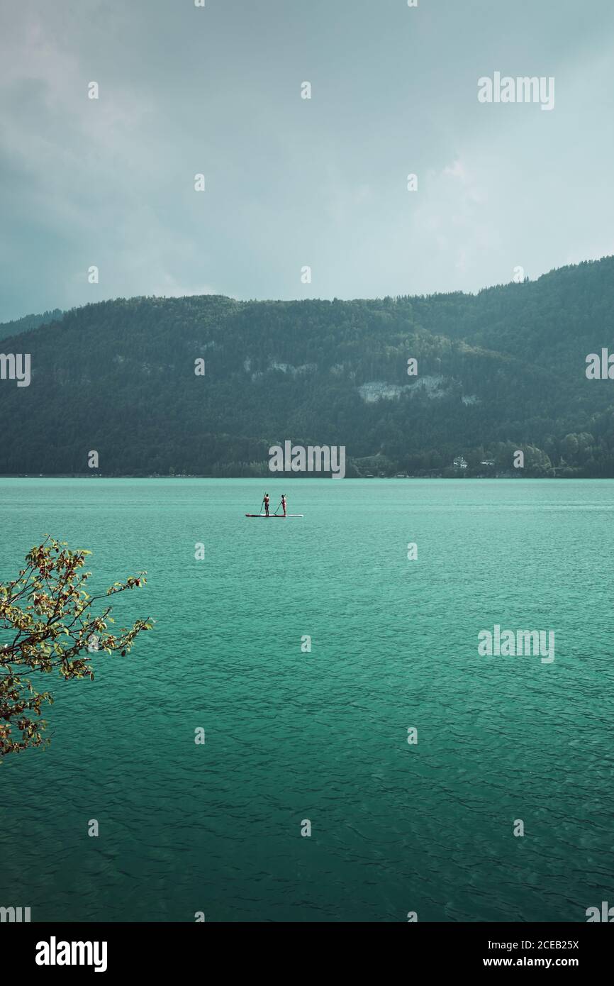 Menschen schwimmen auf Surfbrett auf See Stockfoto