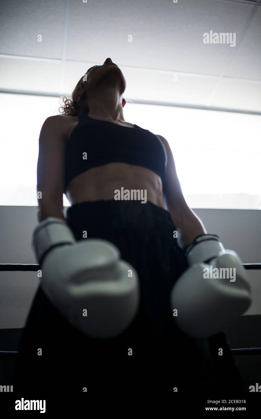 Lockig gesichtslose Erwachsene Frau in schwarz Sport tragen Blick in den Schatten im Fitnessstudio Stockfoto