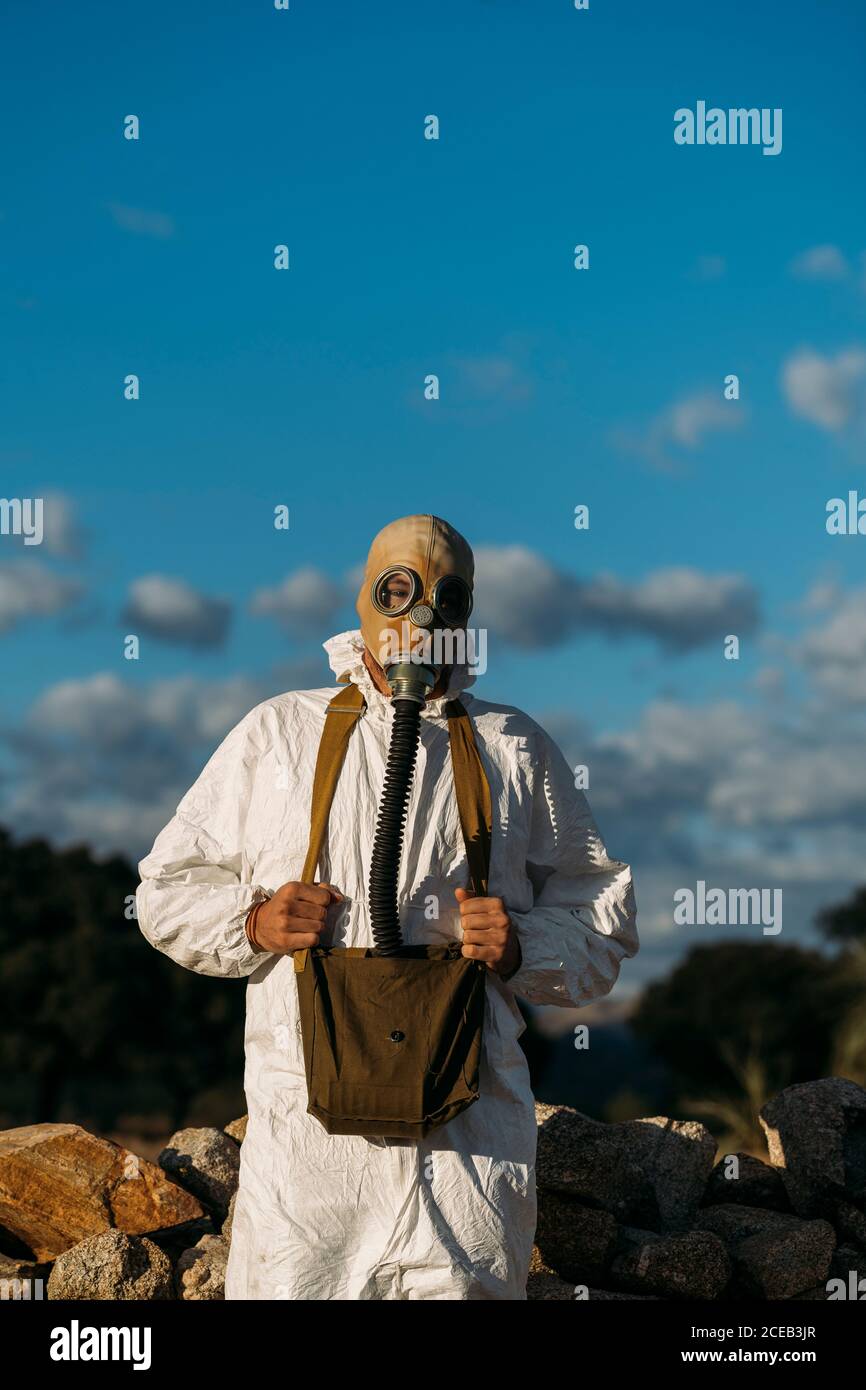 Mann mit Tränengasmaske und weißem Wissenschaftlerkostüm Stockfoto