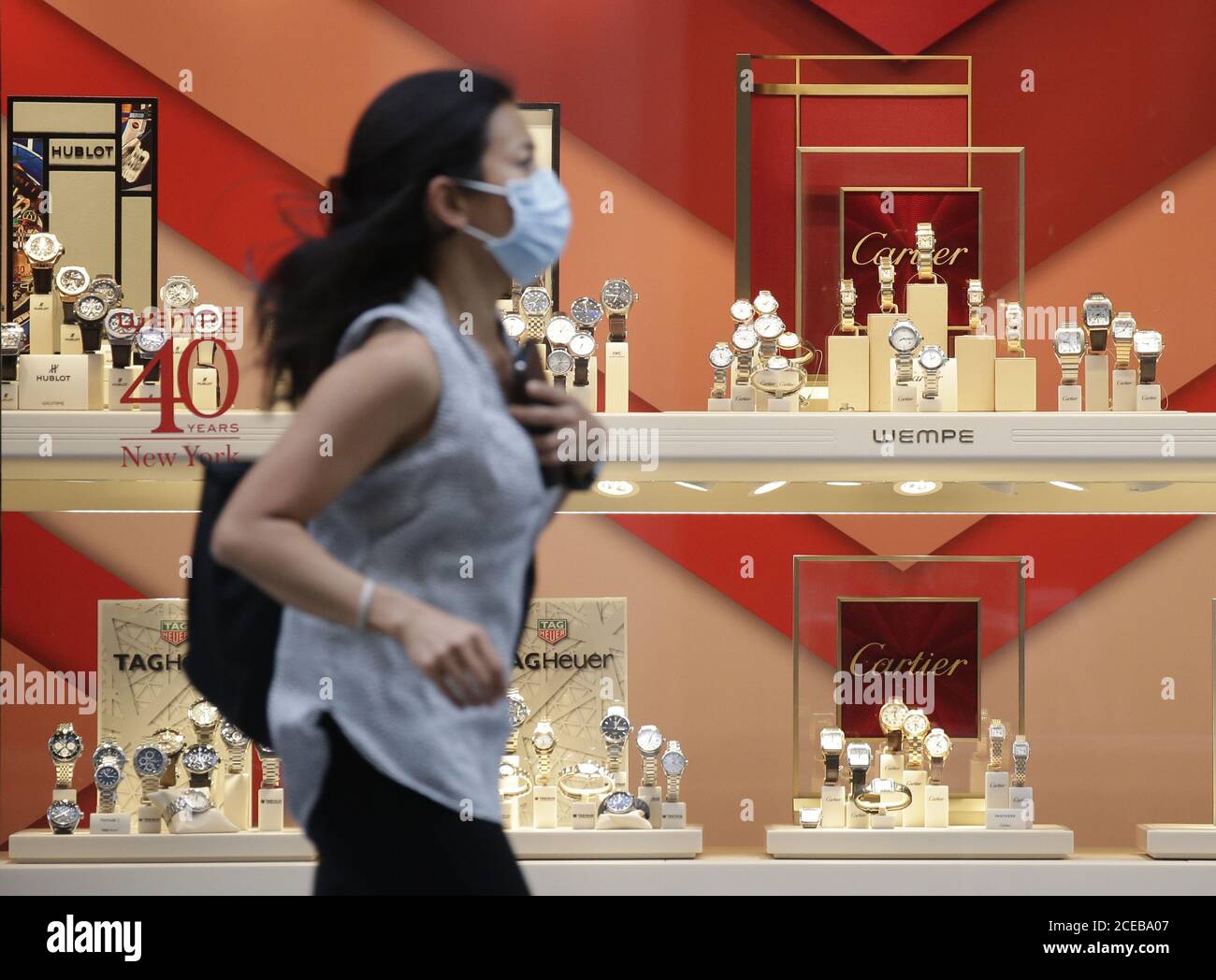 New York, Usa. August 2020. Eine Frau trägt eine Gesichtsmaske, um vor der Ausbreitung des Coronavirus zu schützen und zu verhindern, während sie am Montag, den 31. August 2020, durch eine Ausstellung von Cartier-Uhren auf der Fifth Avenue in New York City joggt. Foto von John Angelillo/UPI Kredit: UPI/Alamy Live Nachrichten Stockfoto
