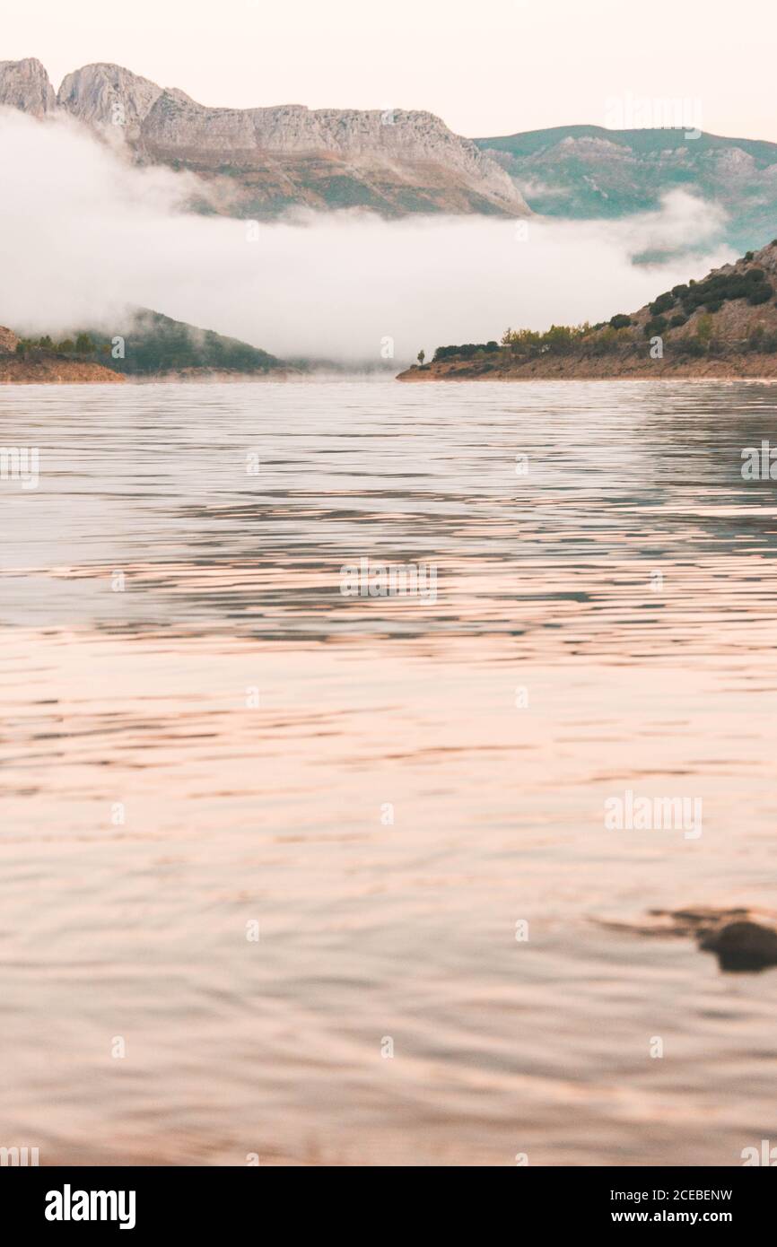 Herrliche Aussicht auf dichten Nebel schwebt über ruhigen See in der Nähe Wunderschöne Berge in Spanien Stockfoto