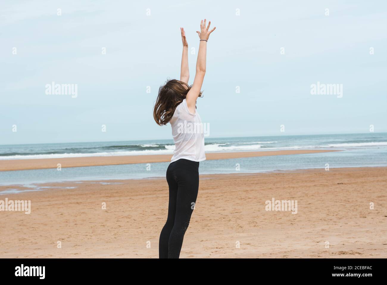 Teenager spielt mit Ball am Strand Stockfoto