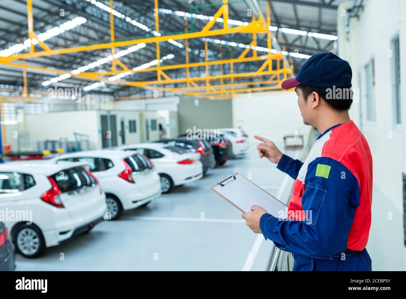 Asian Mann Auto Inspektor Personal Überprüfung Bestand im Auto Service-Center Stockfoto