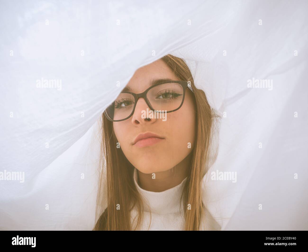 Schöne stolze Teenager in Brillen und weißen tragen Blick auf Kamera  zwischen Lichtvorhängen Stockfotografie - Alamy