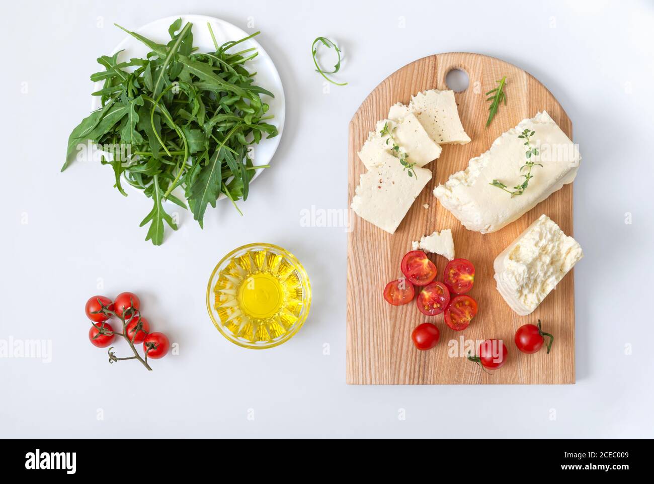Schmackhafter Schaf- oder Ziegenkäse. Stücke von Adyghe Käse auf einem Holzbrett auf weißem Hintergrund. Flach liegend. Landwirtschaftliche Bio-Produkte. Stockfoto