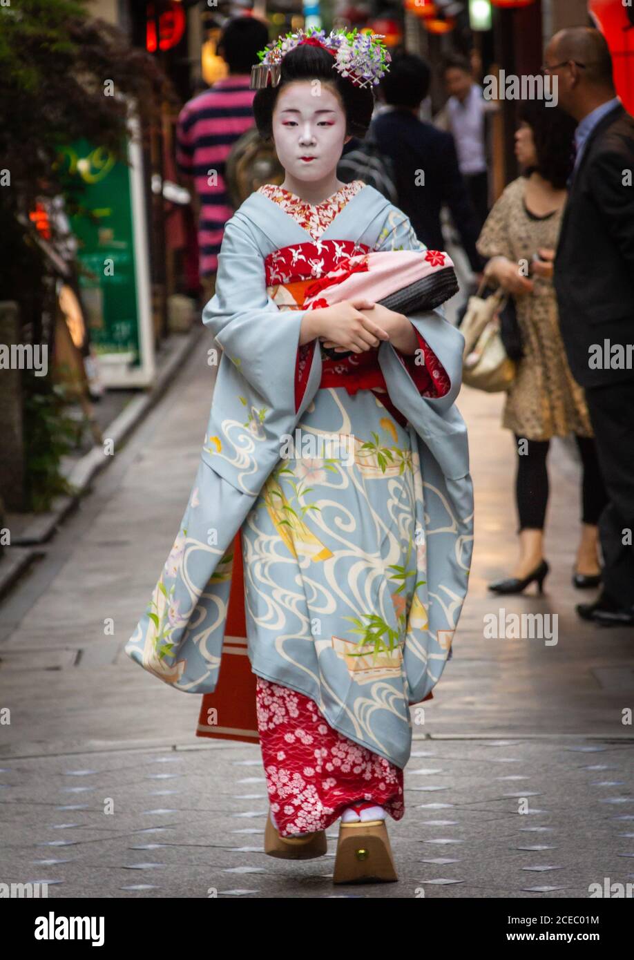 Japan - Mai, 10 2013: Asiatische Frau mit Geisha Make-up tragen traditionelle Kleidung und zu Fuß auf Bürgersteig auf der Stadtstraße Stockfoto