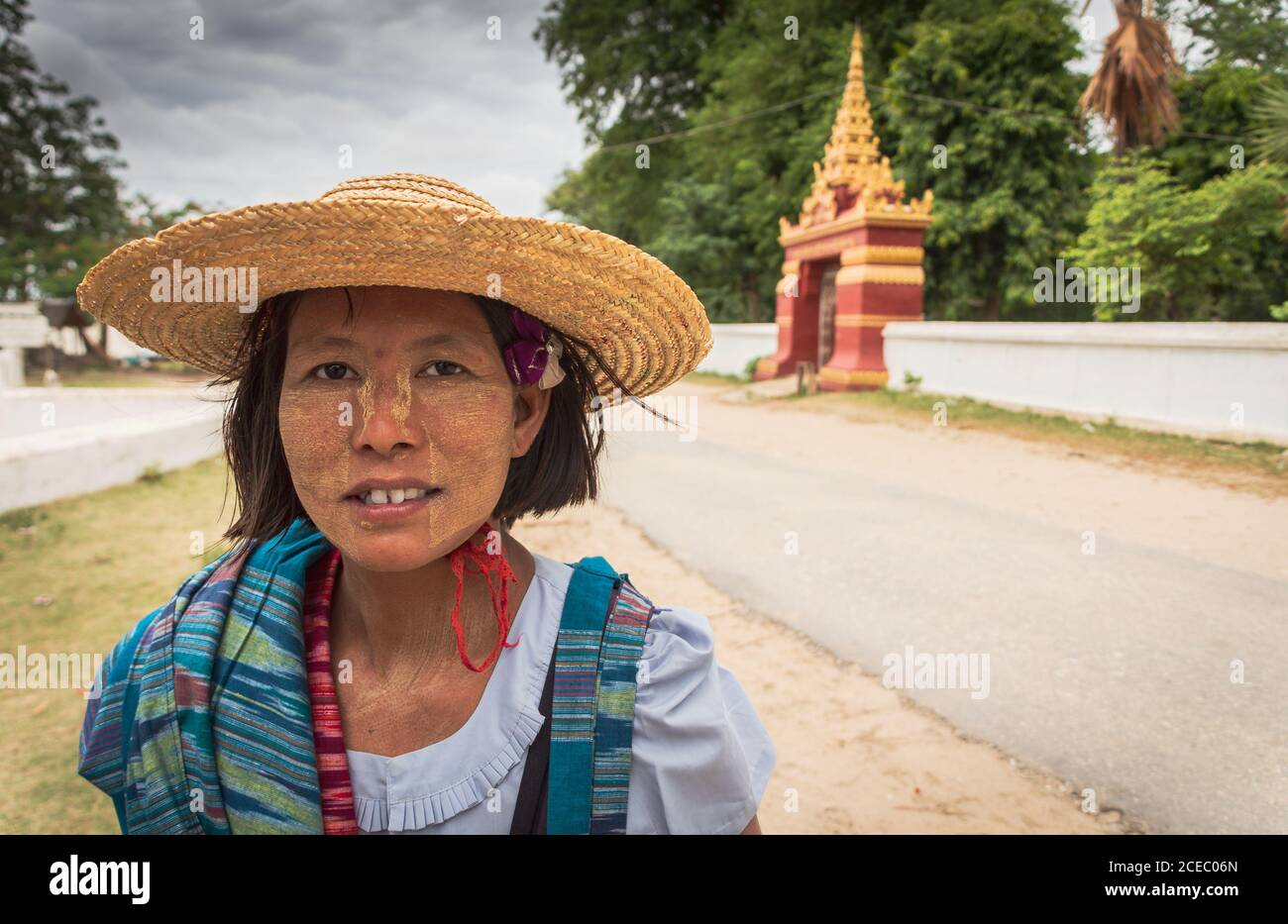 Bagan, Myanmar - Juni, 25 2012: Ethnische Frau mit Farbe auf dem Gesicht Blick auf die Kamera, während sie auf der Straße der Stadt am bewölkten Tag stehen Stockfoto