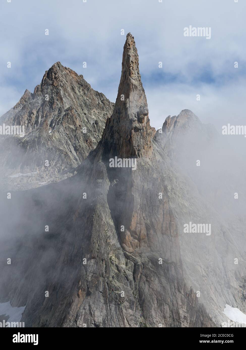 LUFTAUFNAHME. Hoch aufragender Granitgipfel im Nebel. Aiguille de Dibona, Saint-Christophe-en-Oisans, Isère, Auvergne-Rhône-Alpes, Frankreich. Stockfoto