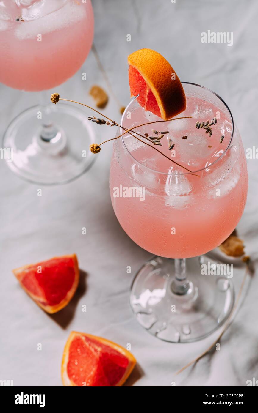 Grapefruit-Cocktail. Alkoholisches Getränk mit tropischen Früchten Lavendel und Eisblumen Stockfoto