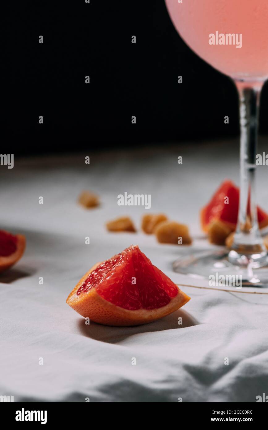 Rosa Grapefruit geschnitten, neben dem Cocktail. Details Stockfoto