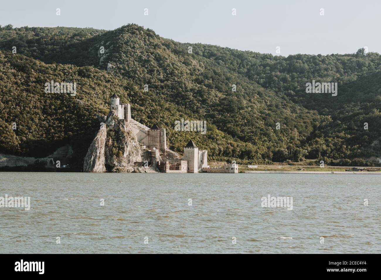 Der Blick auf die Festung Golubac am Ufer des Donau in Serbien an der Grenze zwischen Rumänien und Serbien mit bewaldeten Hügel im Hintergrund Stockfoto