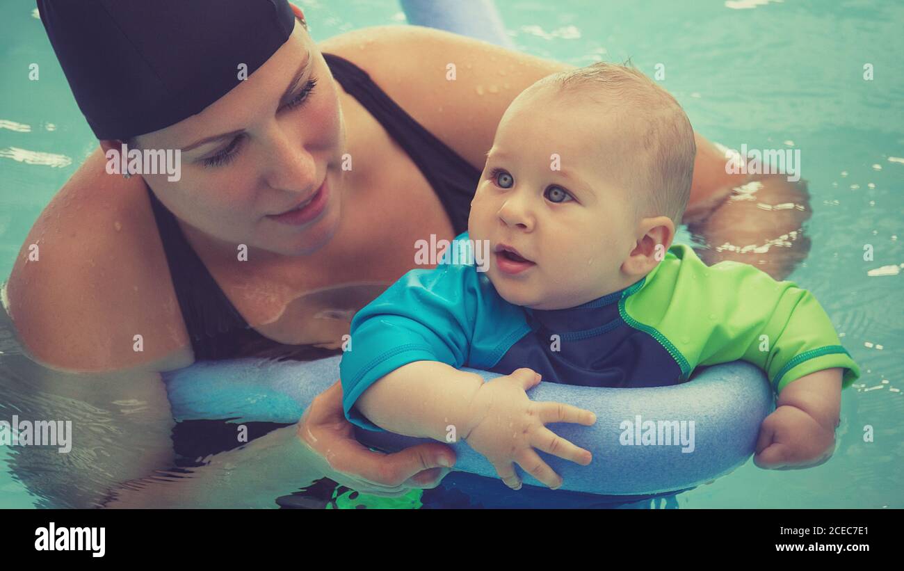 Frau mit kleinen Sohn lernen, im Pool mit aufblasbaren Stick schwimmen