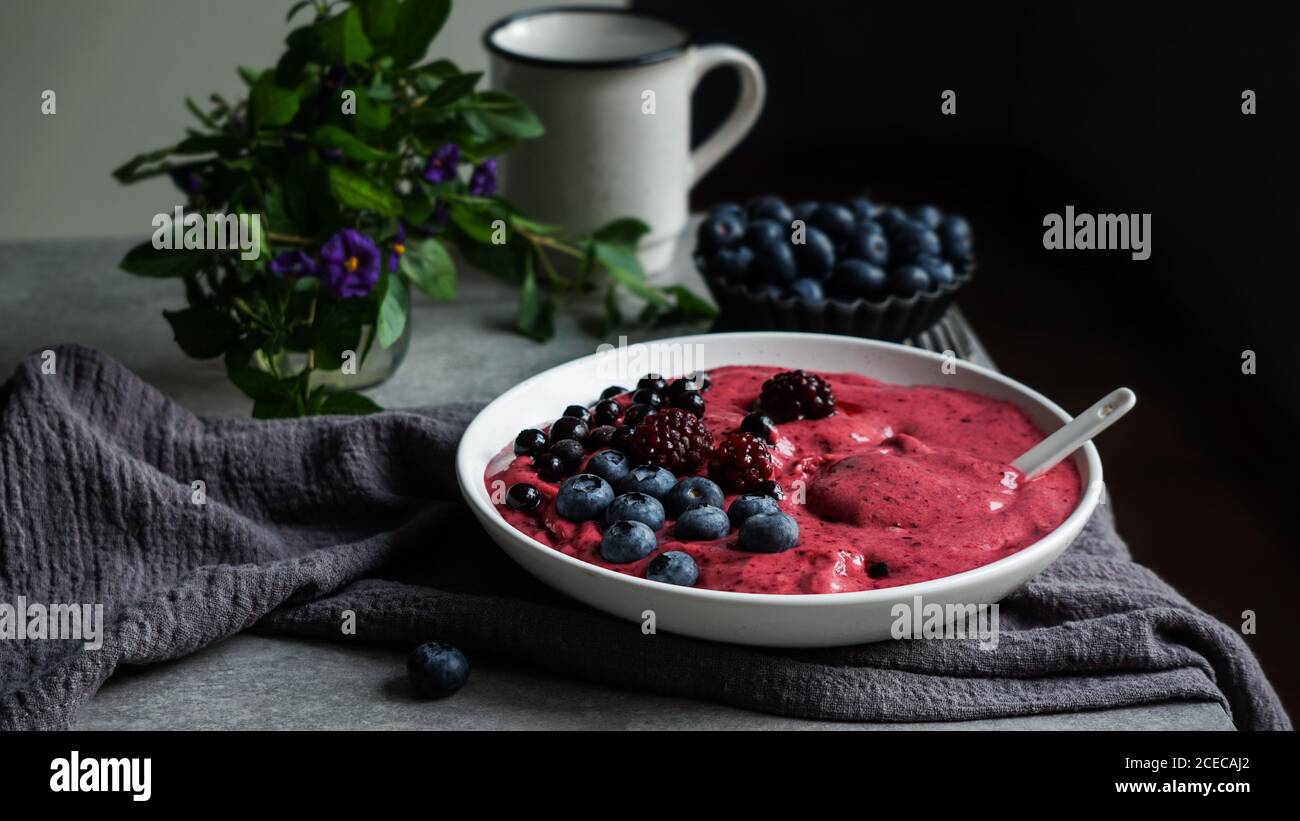 Smoothy von frischen Heidelbeeren und Himbeeren in der Schüssel in der Nähe von Serviette bog Stockfoto
