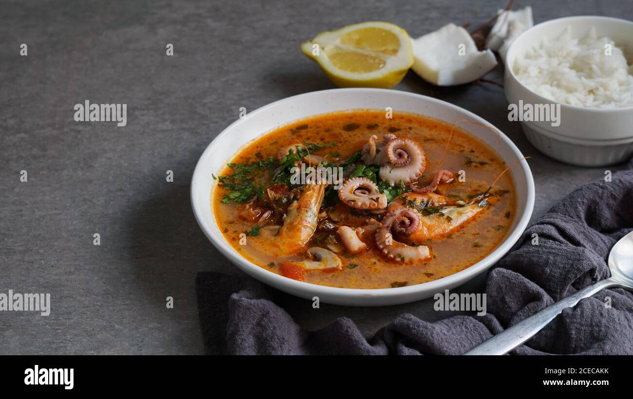 Suppe von Tintenfisch und Garnelen in der Nähe von Reis und Zitrone Stockfoto