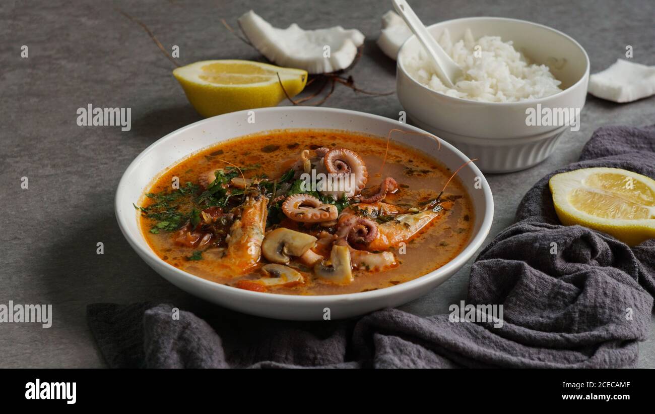 Suppe von Tintenfisch und Garnelen in der Nähe von Reis und Zitrone Stockfoto