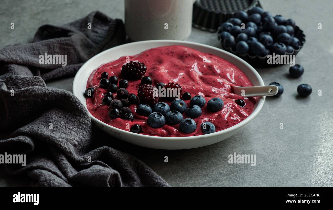 Smoothy von frischen Heidelbeeren und Himbeeren in der Schüssel in der Nähe von Serviette bog Stockfoto