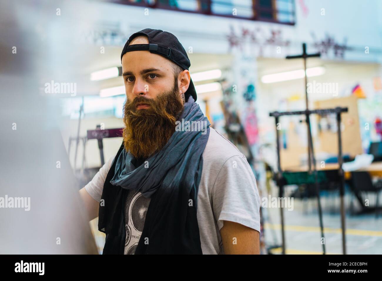 Bärtiger Mann, der auf Staffelei zeichnet Stockfoto