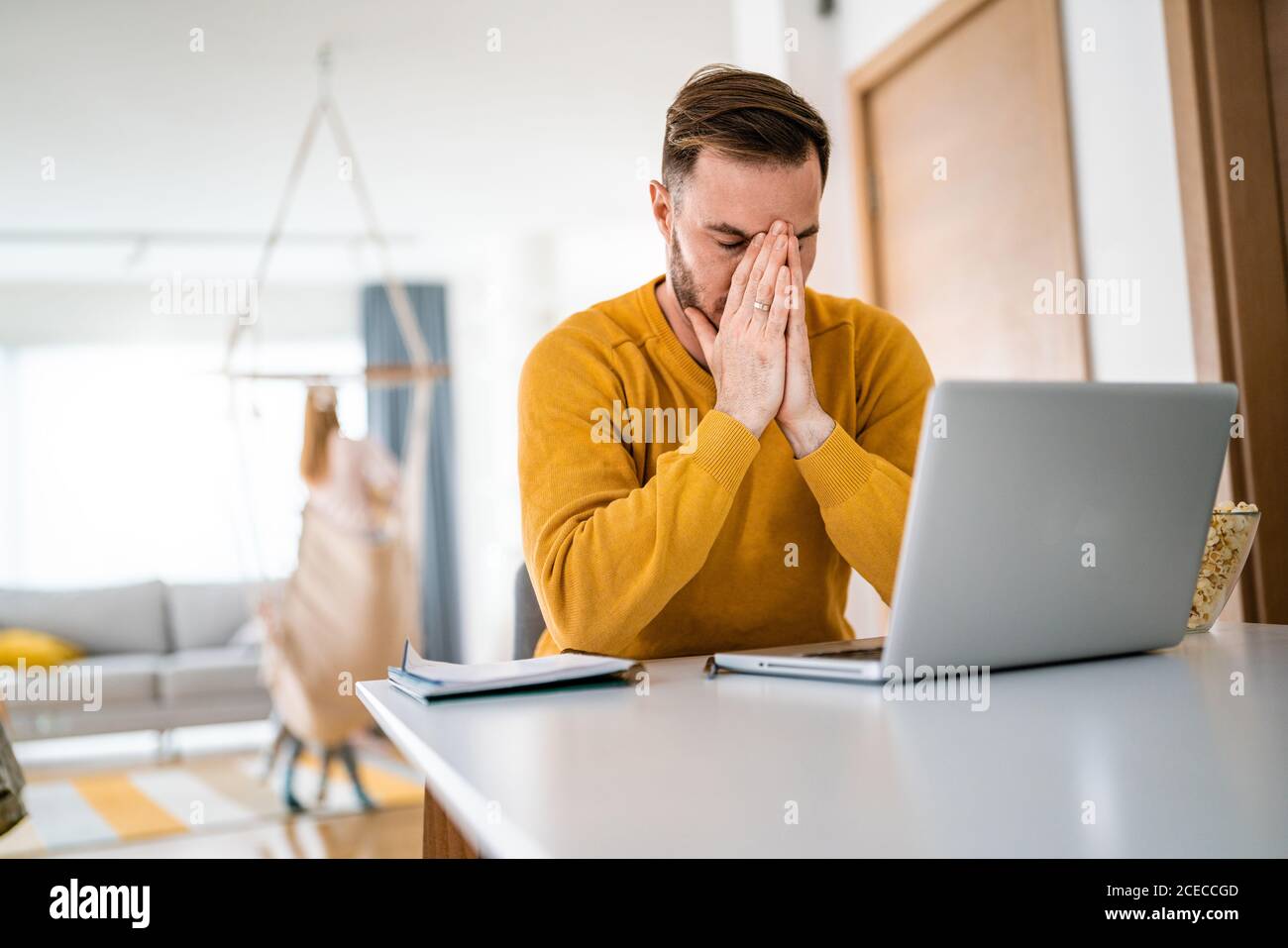 Frustrierter junger Mann, der zu Hause am Laptop arbeitet Stockfoto