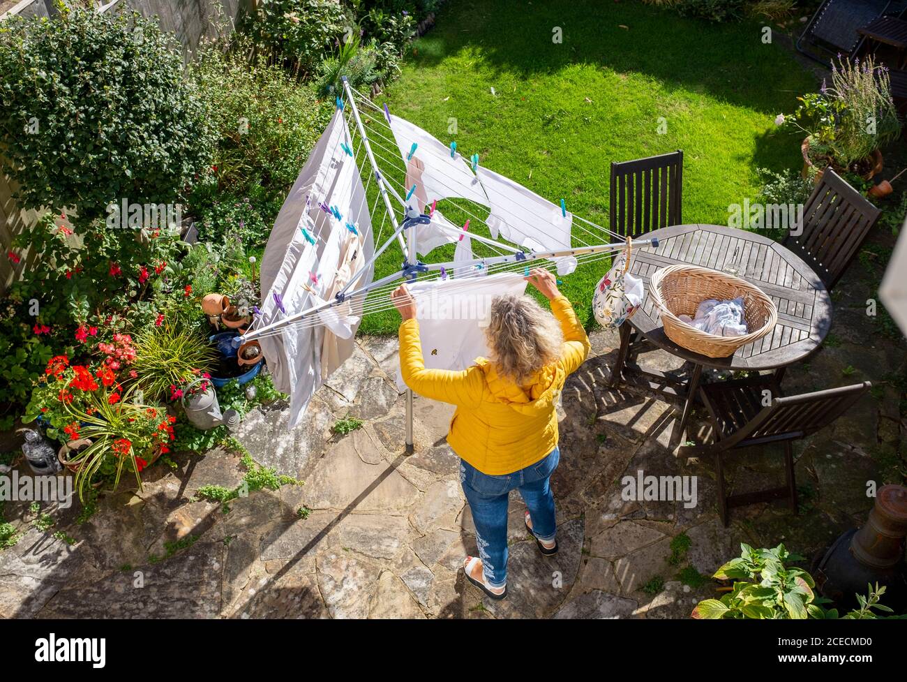 Frau hängt ihre Wäsche an der Drehtrockner-Wäscheleine ab In einem kleinen Gartenhaus in Brighton Stockfoto