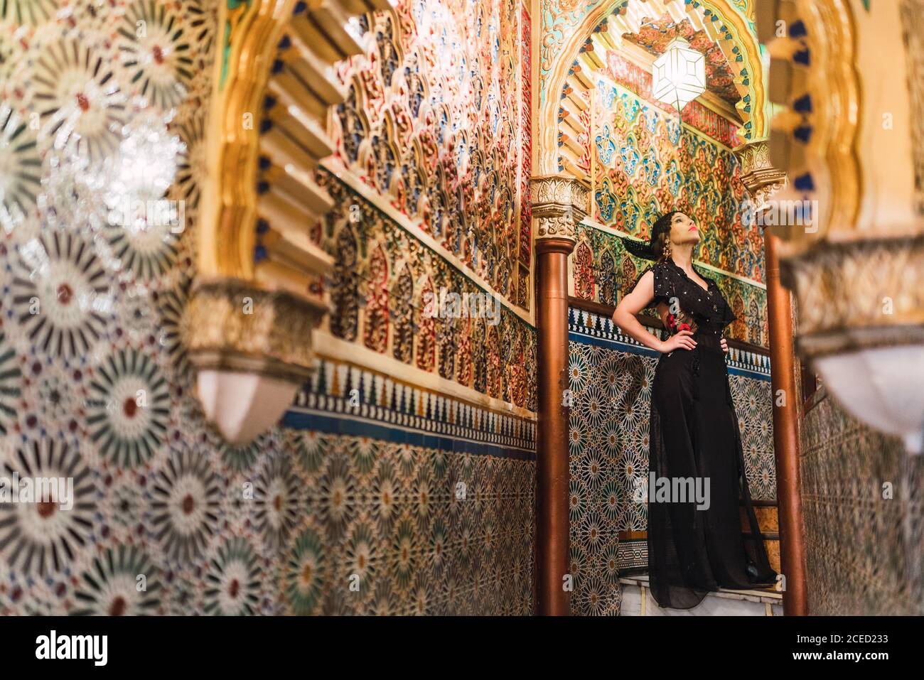 Seitenansicht der leidenschaftliche junge Frau in Kleid stehen in engen Korridor von Mosaik eingerichtet Stockfoto