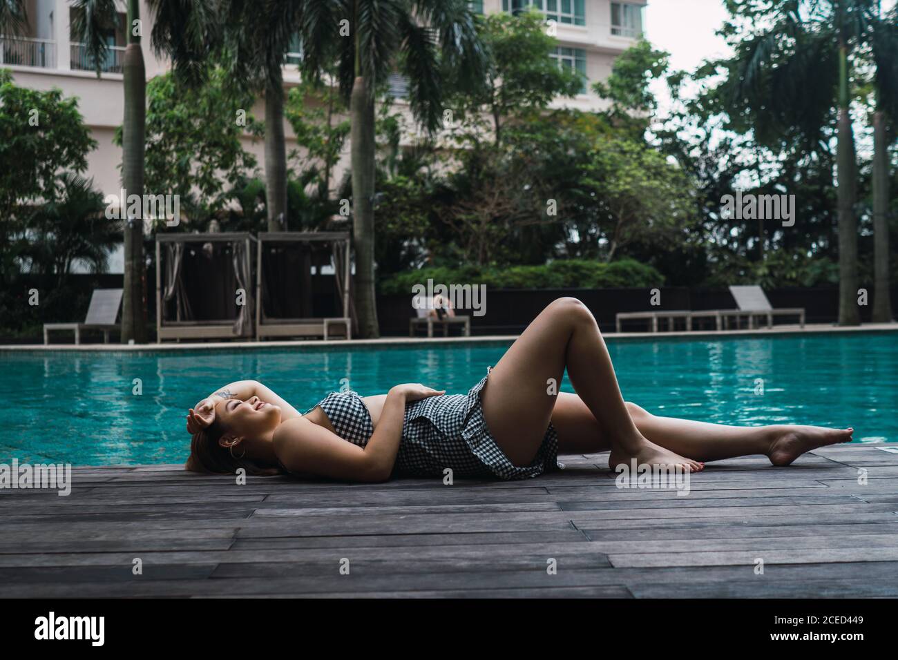 Lächelnde Frau, die sich am Pool entspannt Stockfoto