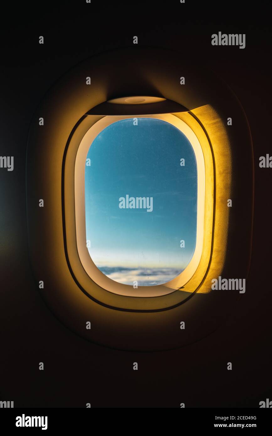 Aufnahme aus dem Flugzeugfenster mit blauem Himmel dahinter Beleuchtet mit goldenen Lichtern des Sonnenuntergangs Stockfoto