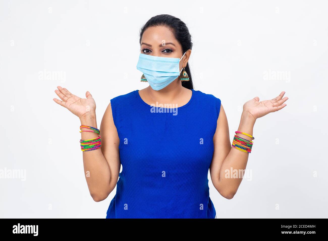 Hübsche indische Frau trägt Covid-19 Schutzmaske. Frau mit offenen Armen in entspannter Position. Stockfoto