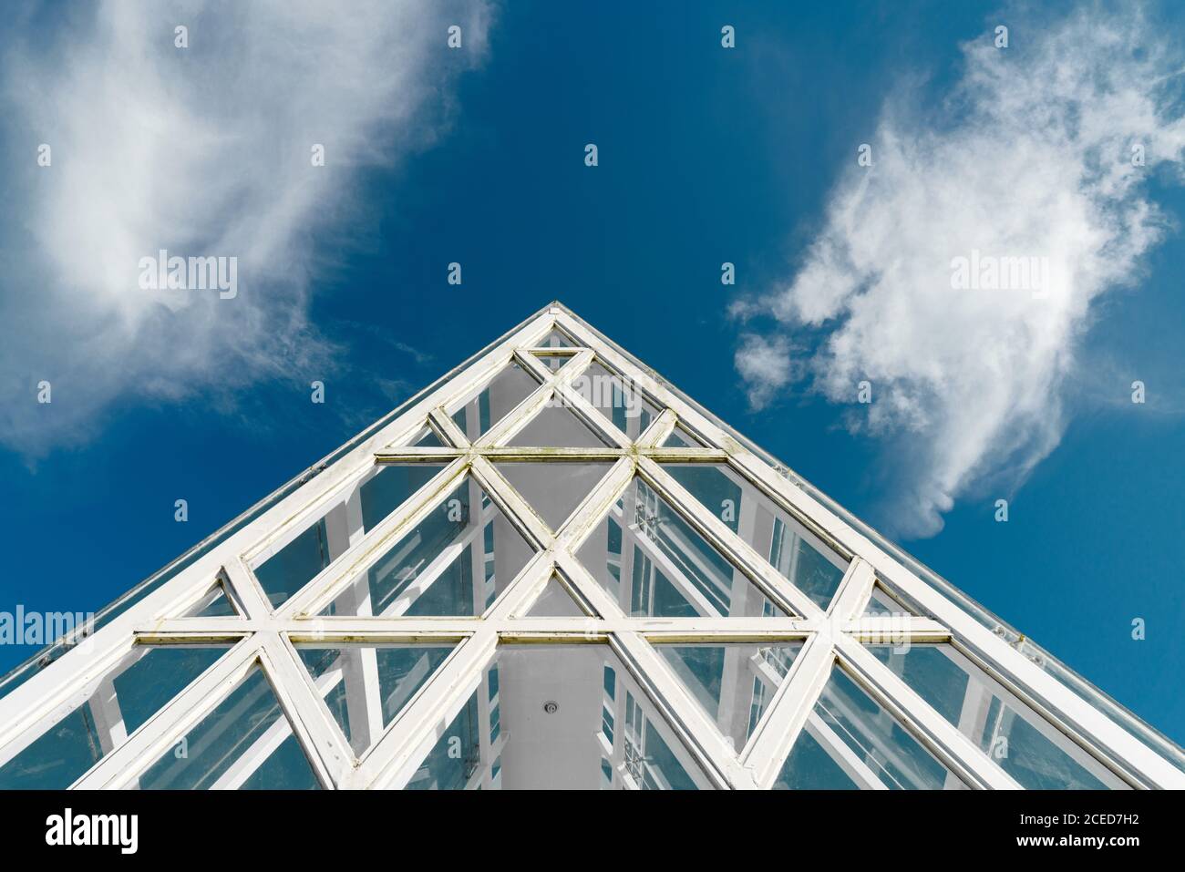 Von unten Schuss der Glaskonstruktion des Hangdaches mit weißen Balken unter blauem Himmel, Phoenix Park, China Stockfoto