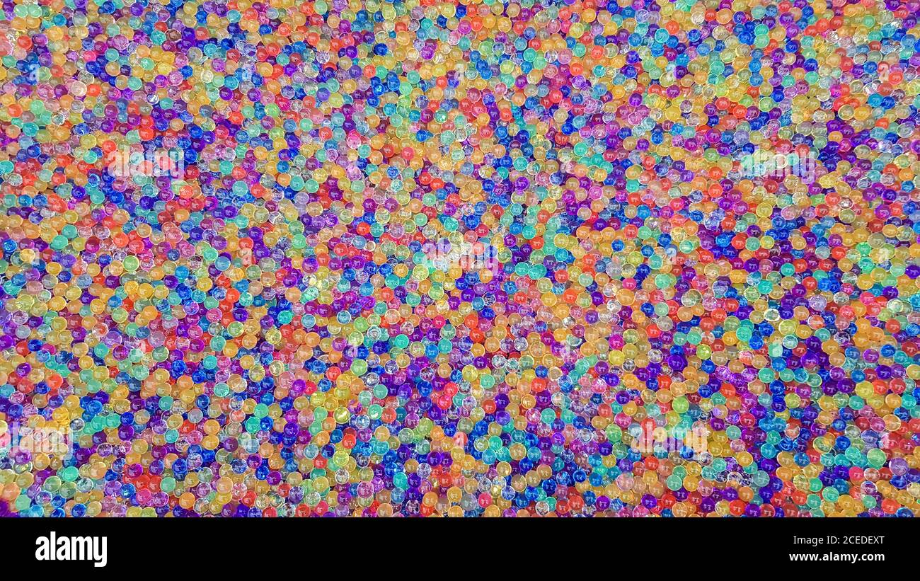 Viele verschiedene farbige Hydrogelkugeln. Set von mehrfarbigen orbis. Kristallwasserperlen für Spiele. Heliumballons. Kann als Hintergrund verwendet werden. Poly Stockfoto