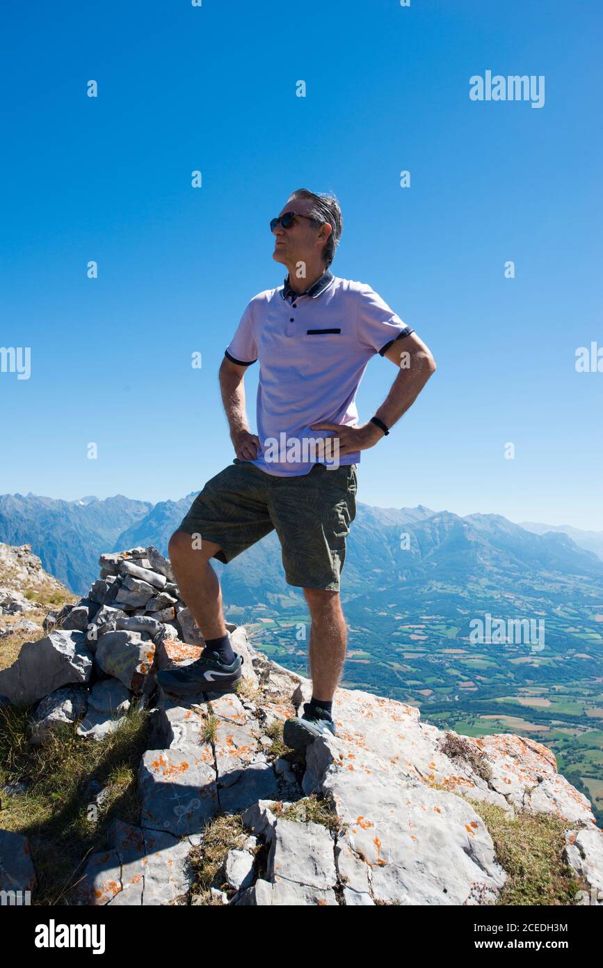 Erwachsener Mann, der eine Pause nach dem Besteigen eines Berges nimmt Stockfoto