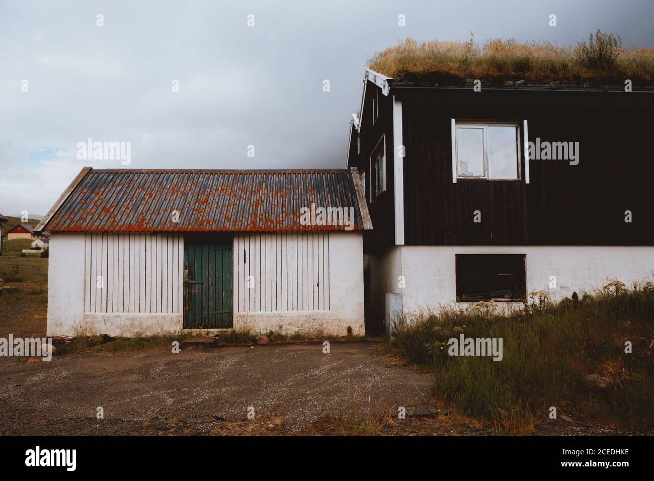 Braune grungige ländliche Häuser mit trockenem Gras auf Dächern in Feroe Island Stockfoto