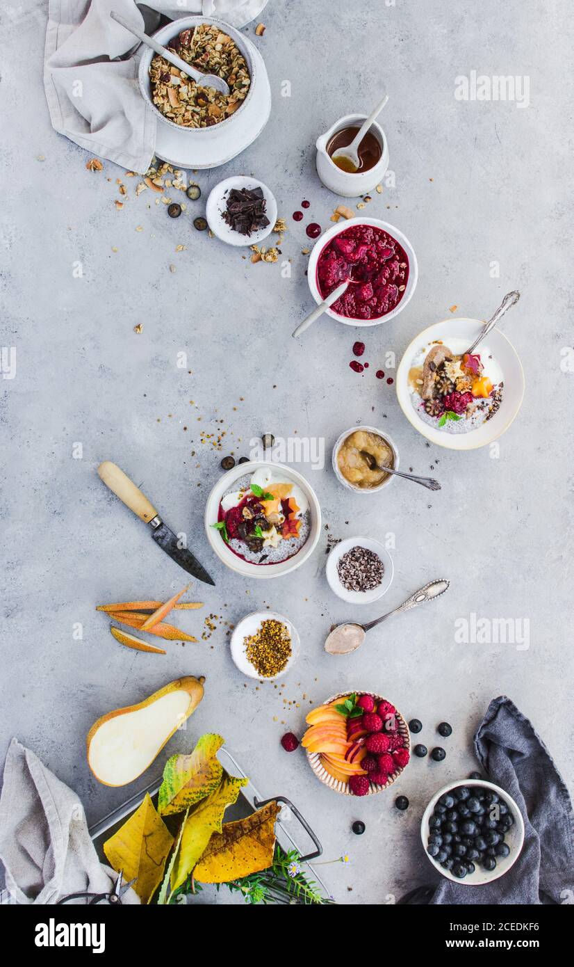 Von oben Schuss von köstlichen Chia Parfait und verschiedene Früchte Und Korn liegen auf Marmor-Tischplatte Stockfoto