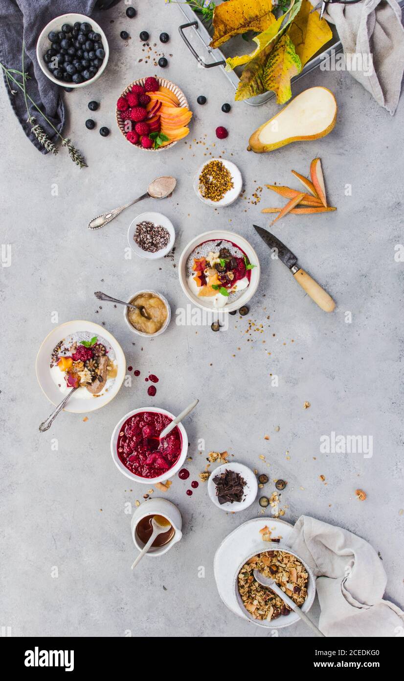 Von oben Schuss von köstlichen Chia Parfait und verschiedene Früchte Und Korn liegen auf Marmor-Tischplatte Stockfoto