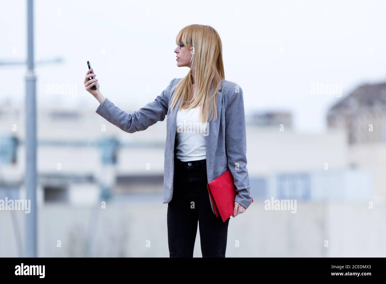 Junge blonde Dame bleibt und macht Selfie Stockfoto