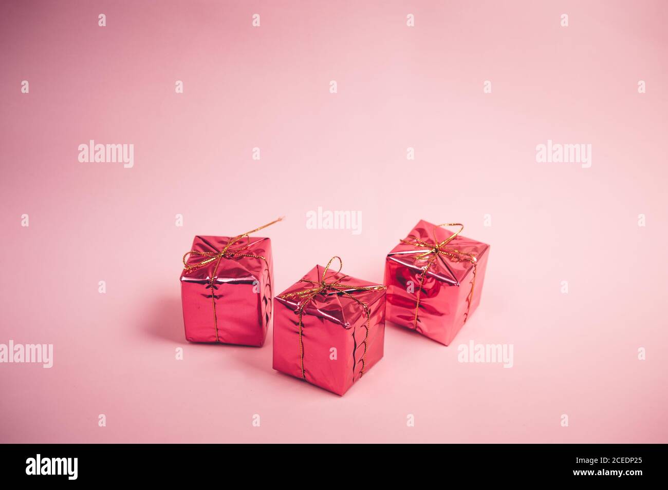 Drei rosa Geschenke auf einem rosa Hintergrund Stockfoto