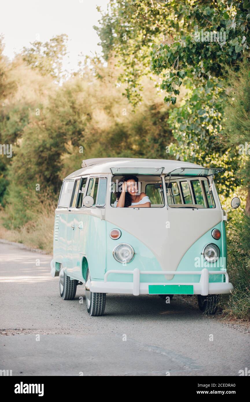 Lächelnde Frau, die im Retro-Auto sitzt Stockfoto